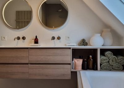 Moderne badkamer met dubbele wastafel, ronde spiegels en houten badkamermeubel