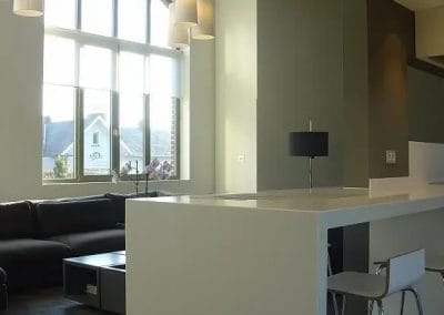 Moderne leefruimte met keukenbar, hoge plafonds en groot boograam