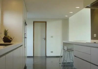 Moderne keuken met kookeiland, strakke kasten en donkere vloer