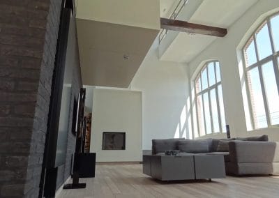 Moderne woonkamer met hoge plafonds, grote boogramen en veel daglicht