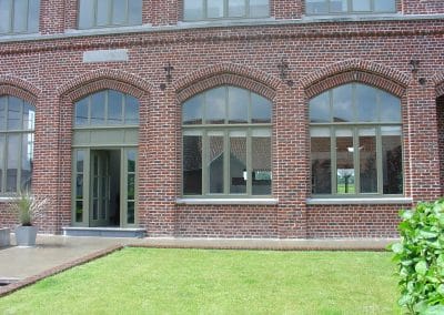 Woning met bakstenen gevel, grote raampartijen en zicht op tuin