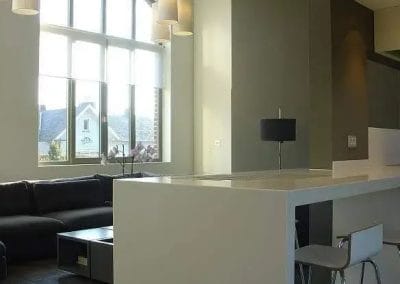 Moderne leefruimte met keukenbar, hoge plafonds en groot boograam