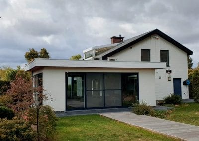Gerenoveerde woning met moderne aanbouw, grote ramen en tuin